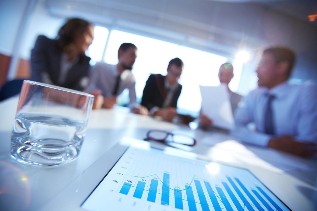 Business team discussing data charts in a meeting room.