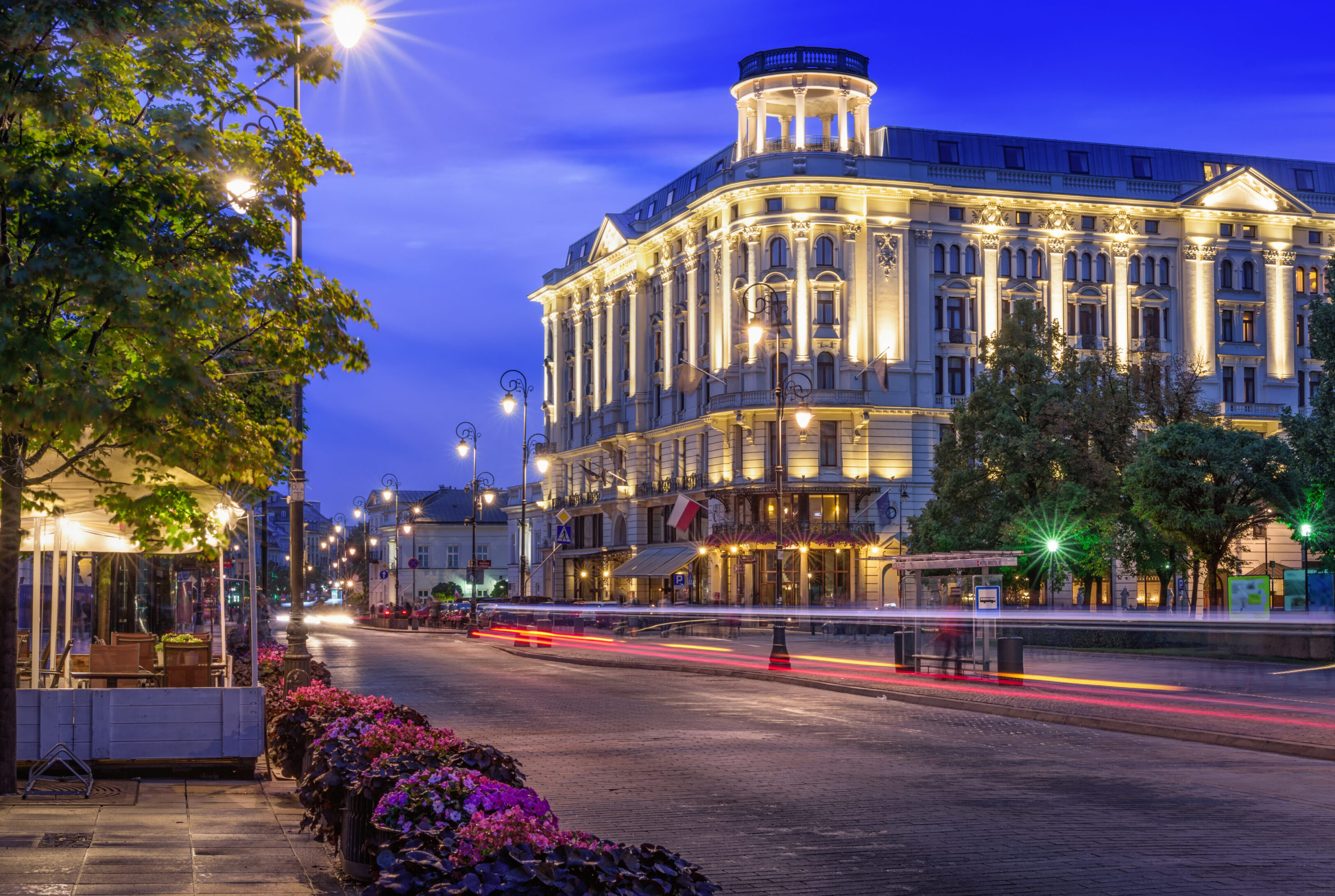 Elegant building lit up at night on a bustling city street.