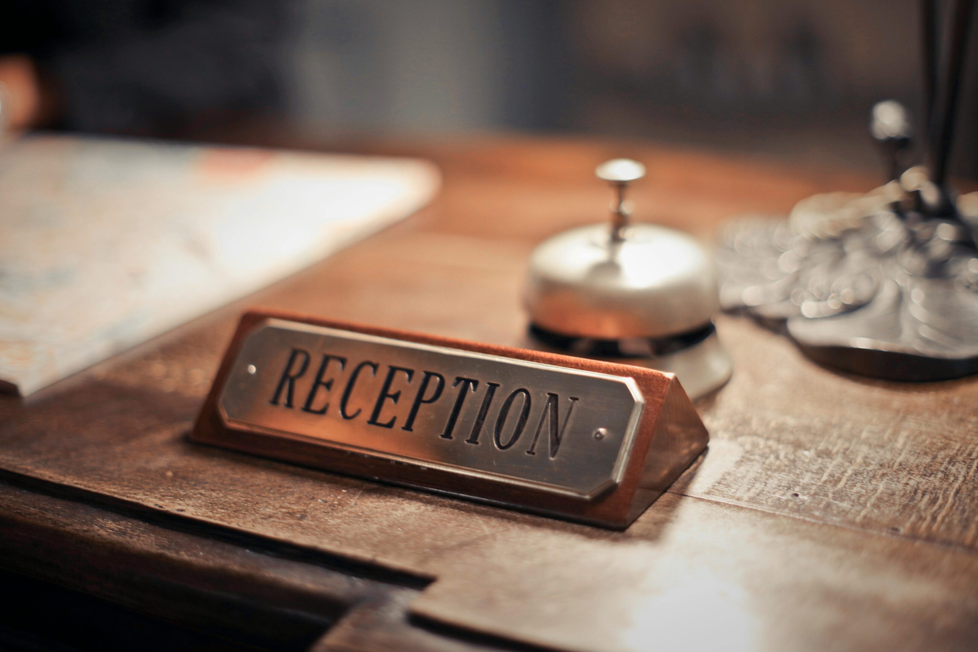Vintage reception desk sign with a service bell.